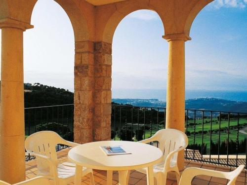 een tafel en stoelen op een balkon met uitzicht bij Apartment Hapimag-1 by Interhome in Platja  d'Aro