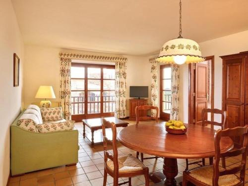 een woonkamer met een houten tafel en een eetkamer bij Apartment Hapimag-1 by Interhome in Platja  d'Aro