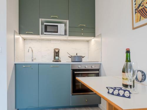 une cuisine avec des armoires bleues et un comptoir dans l'établissement Apartment Fleur Marine-34 by Interhome, à Cabourg