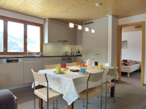 kuchnia i jadalnia ze stołem i krzesłami w obiekcie Apartment Chalet Gredetsch by Interhome w mieście Bürchen