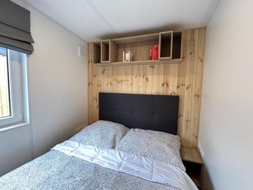 a bedroom with a bed with a wooden wall at Holiday Home Tanjas Tiny Haus by Interhome in Wemding