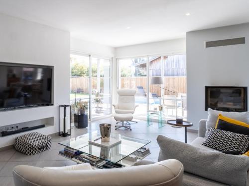 Il comprend un salon doté d'un mobilier blanc et d'une télévision à écran plat. dans l'établissement Villa Plein Air by Interhome, à Gujan-Mestras
