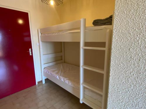 a white bunk bed in a room with a red door at Les Sardines in Valras-Plage