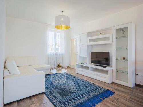 Una sala de estar con un sofá blanco y un televisor. en Apartment La casa dei limoni di Valeria by Interhome, en Torre del Lago Puccini