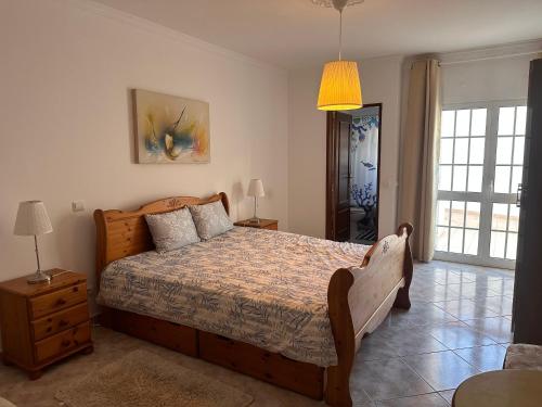 - une chambre avec un lit doté d'un cadre de lit en bois dans l'établissement Dream House Near the Beach, à Porches