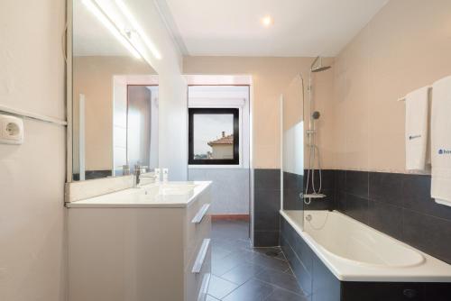 a bathroom with a tub and a sink and a bath tub at Host Wise - Charming Spacious Duplex House in Infesta