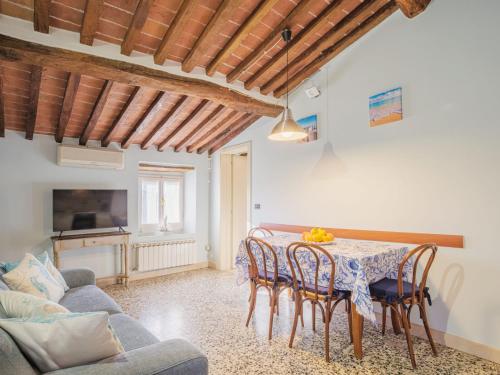 - un salon avec une table, des chaises et un canapé dans l'établissement Apartment Casina stella al mare by Interhome, à Querceta
