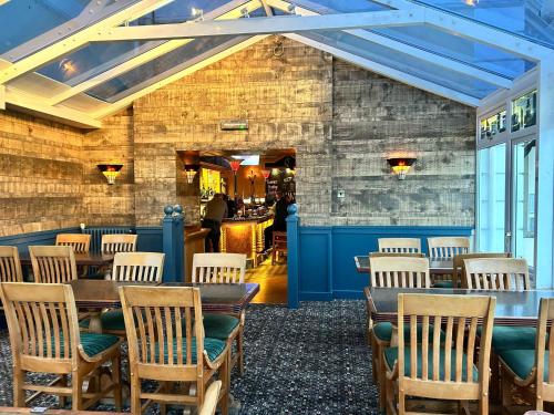 a restaurant with tables and chairs and a bar at The Heritage Hotel in Torquay