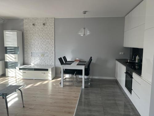 uma cozinha branca com uma mesa e cadeiras em Apartament Gwiazdowa em Lódź