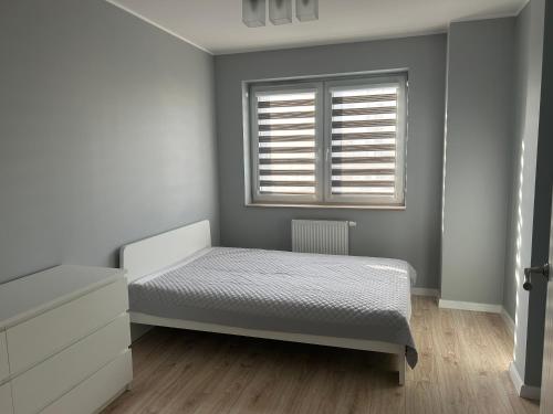 um quarto com uma cama e uma janela em Apartament Gwiazdowa em Lódź
