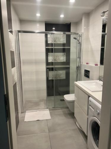 uma casa de banho com um chuveiro, um WC e um lavatório. em Apartament Gwiazdowa em Lódź
