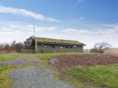 a house with a grass roof on top of a field at Holiday Home Hunlef - 1-7km from the sea in Western Jutland by Interhome in Bolilmark