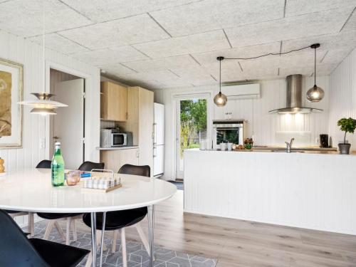 eine Küche und ein Esszimmer mit einem weißen Tisch in der Unterkunft Holiday Home Marielouise - from the sea in NE Jutland by Interhome in Hals