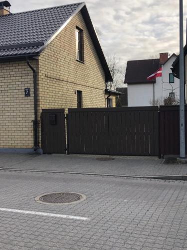 una casa con una recinzione accanto a una strada di Evija a Ventspils