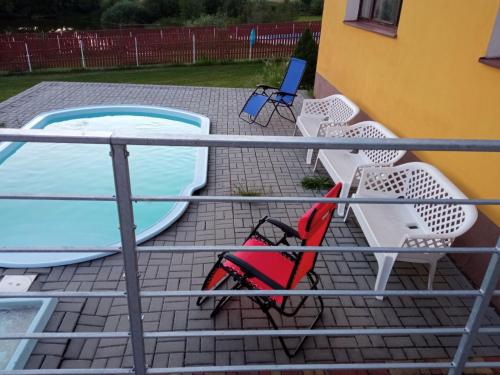 a deck with chairs and a swimming pool at Holiday Home Smrž by Interhome in Dudov
