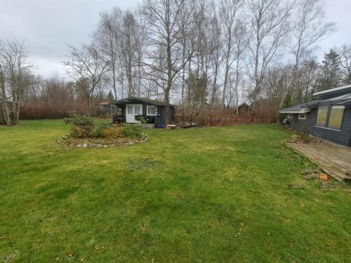 a yard with a small house and a house at Holiday Home Sybille - all inclusive - 30km from the sea by Interhome in Fårvang