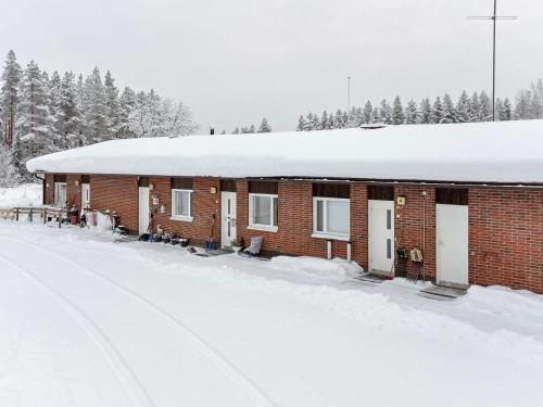 un bâtiment recouvert de neige avec beaucoup de neige dans l'établissement Holiday Home Ylä-luosta by Interhome, à Rautavaara
