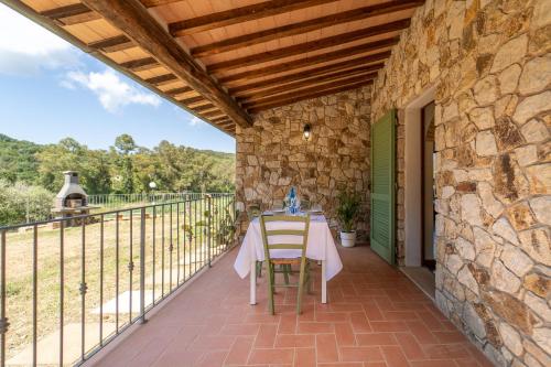a table and chairs on a patio with a stone wall at Apartments La Tenuta where the sea meets the land - Goelba in Porto Azzurro