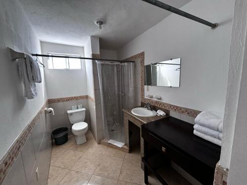a bathroom with a shower and a toilet and a sink at Whale Hill in Puerto Peñasco