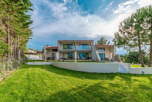 a large house with a lawn in front of it at Pelagus Luxury Villas in Polykhrono