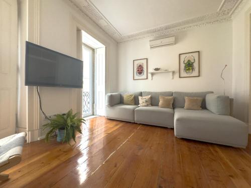 a living room with a couch and a flat screen tv at Home Mais 36 in Lisbon