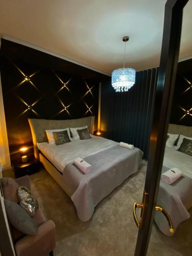 a bedroom with a large bed and a chandelier at Mystik Penthouse in Sighişoara