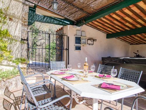 a white table and chairs on a patio at Holiday Home La maison aux volets bleus by Interhome in Entrecasteaux