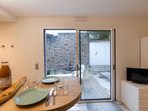 d'une salle à manger avec une table et une porte coulissante en verre. dans l'établissement Studio L'Oiseau 2 by Interhome, à Dinard