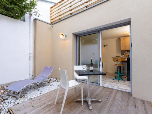 - une terrasse avec une table et des chaises ainsi qu'une bouteille de vin dans l'établissement Studio L'Oiseau 2 by Interhome, à Dinard