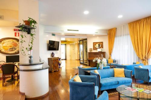 ein Wohnzimmer mit blauen Sofas und einem Tisch in der Unterkunft Melas Hotel in Merate