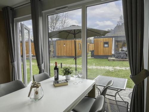un tavolo bianco con una bottiglia di vino e una finestra di Holiday Home Tiny Haus Libelle by Interhome a Riedenburg