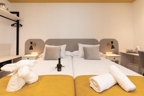 un osito de peluche blanco sentado en una cama con toallas en Boutique Rooms Playa Burriana, en Nerja