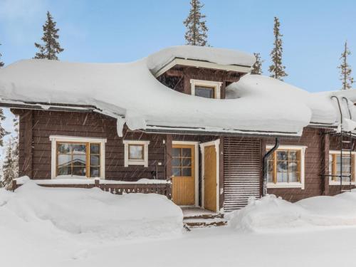 uma casa coberta de neve com telhados cobertos de neve em Holiday Home Hankirati 8a by Interhome em Ruka