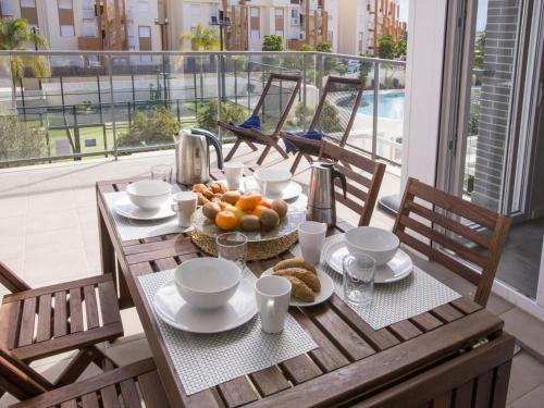 a table with a plate of food on a balcony at Apartment Victoria Playa III Plus by Interhome in Denia