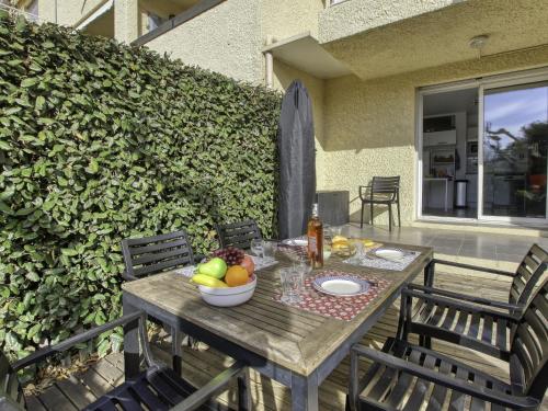 - une table en bois avec un bol de fruits sur la terrasse dans l'établissement Apartment L'Ile heureuse-8 by Interhome, à Saint-Cyr-sur-Mer
