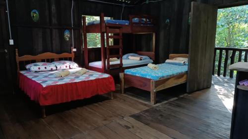 a bedroom with two beds and a bunk bed at Cabaña blue jeans in San Ramón