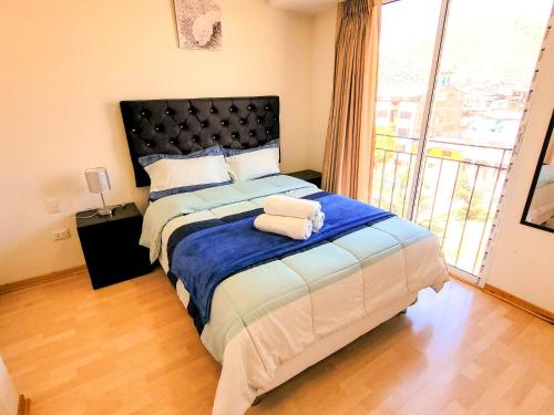 een slaapkamer met een groot bed en een groot raam bij Fiflos Apartament in Cuzco