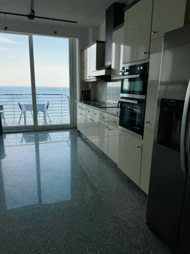 una cucina con mobili bianchi e vista sull'oceano di Seaview Tower Apartment a Sliema