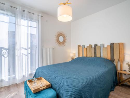une chambre avec un lit bleu et une grande fenêtre dans l'établissement Apartment Villa Anna-1 by Interhome, à Arcachon