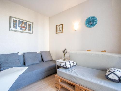 un salon avec un canapé et une horloge au mur dans l'établissement Studio Port Arcachon-7 by Interhome, à Arcachon