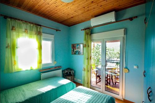 a bedroom with blue walls and a bed and a window at Villa Sofia in Samos
