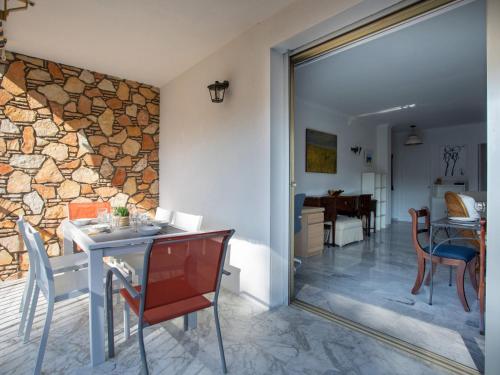 une salle à manger avec une table et des chaises et un mur en pierre dans l'établissement Apartment Val Joli-2 by Interhome, à Cannes