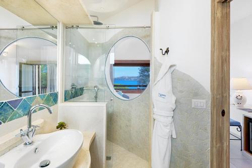 bagno con lavandino e specchio di Hotel Capo d'Orso Thalasso & SPA a Palau