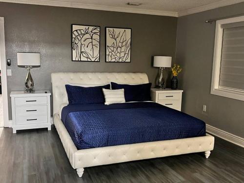 a bedroom with a white bed and two night stands at King Bed, 3 miles to Stadium in Miami Gardens