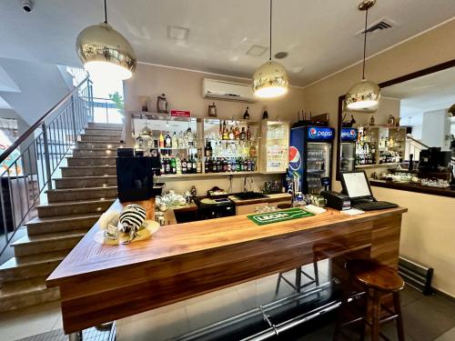 a bar with a wooden counter and a staircase at Hotel Pod Dębami in Ostrów Wielkopolski