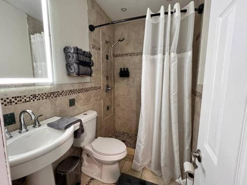 een badkamer met een toilet, een wastafel en een douche bij King Bed, 3 miles to Stadium in Miami Gardens