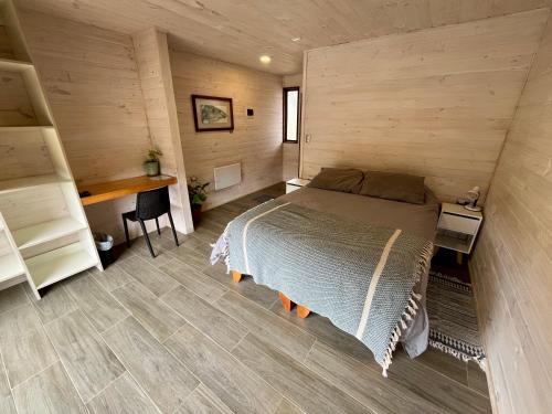 een slaapkamer met een bed en een bureau in een kamer bij VIENTO BRAVO in Pichilemu