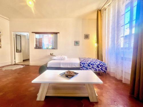 a bedroom with two beds and a table in it at AA OT Maison du Moulin - Old Town - Promenade des in Nice