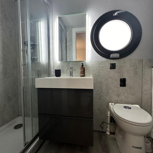 a bathroom with a sink and a toilet and a mirror at La Mare Resort in Gothenburg