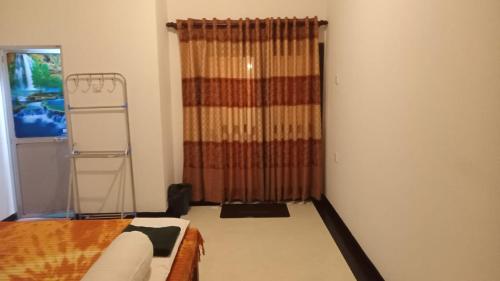 1 dormitorio con cama y ventana con cortina en Little Villa Guest House en Ahangama